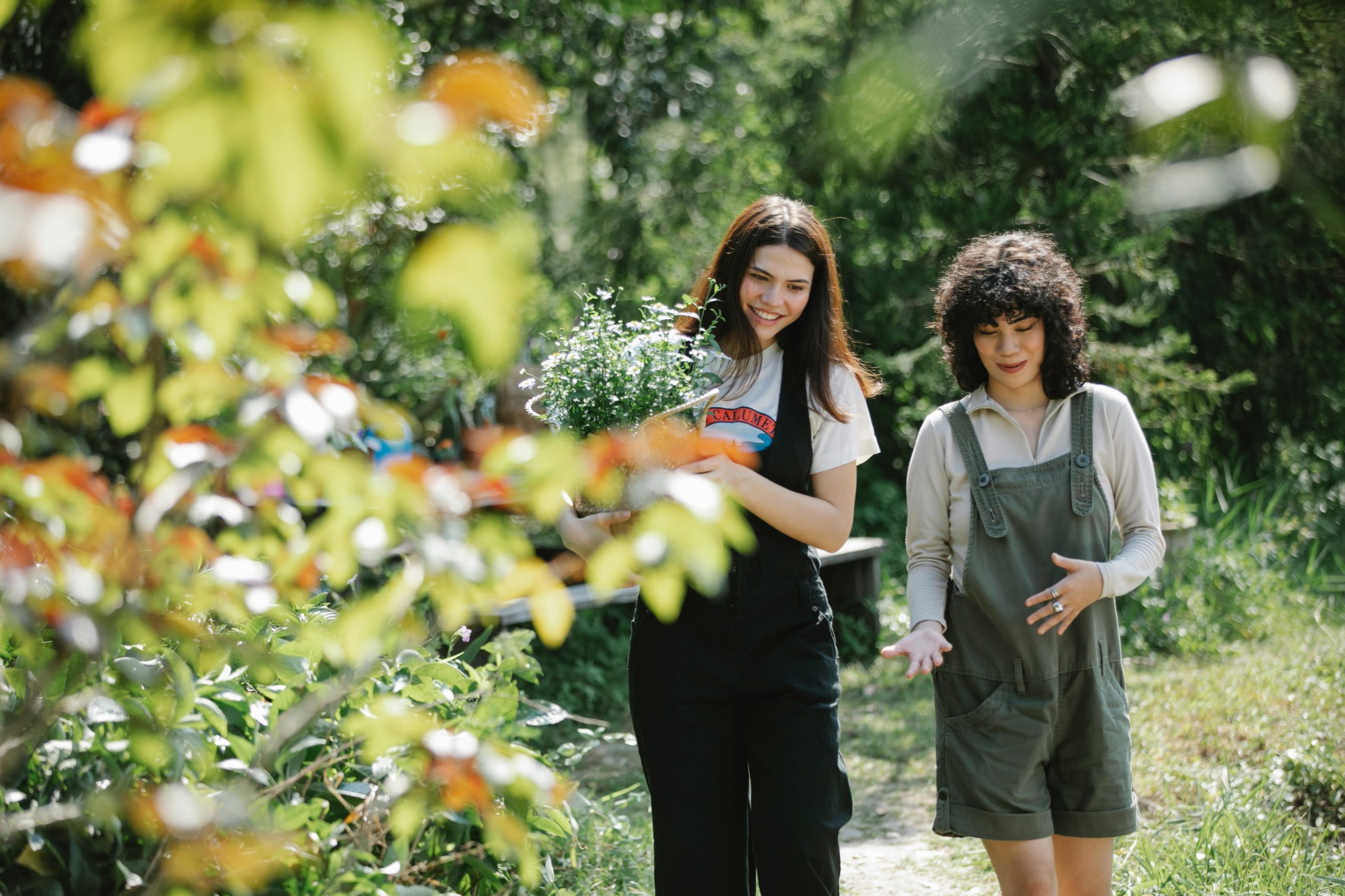 2 femmes parlent en marchant dans un parc arboré